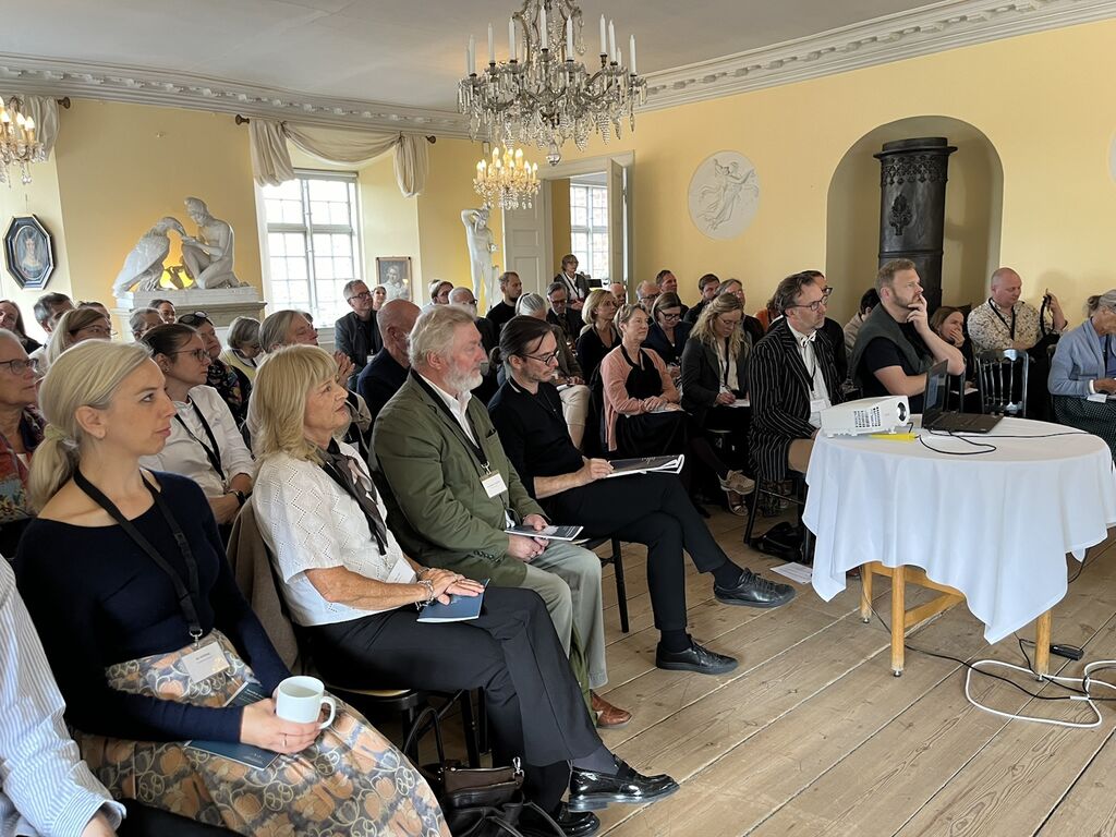 Forsamling sidder og lytter i Thorvaldsen-Sal på herregården Broholm